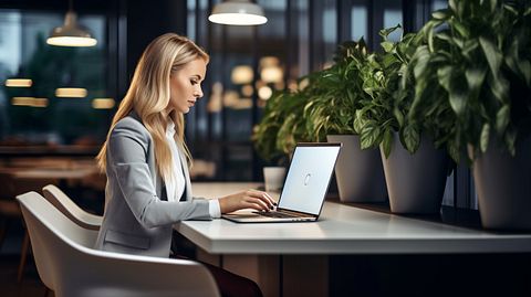 A tech-savvy real estate broker working hard, consulting with her clients and tapping away at her laptop.