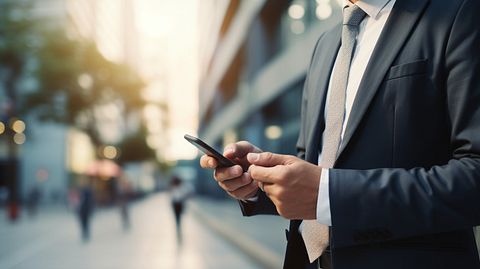 A successful business professional using a mobile device to access the company's innovative online B2B and B2C commerce solutions.