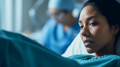 A close-up of a nurse in her blue scrubs taking care of a patient in a home health setting.