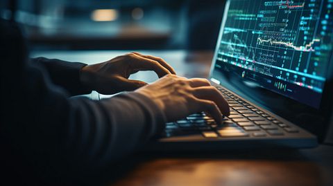 A person's hands typing on a keyboard, circling around a wealth management platform, signifying the company's cutting-edge technology.