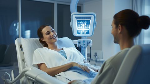 A smiling healthcare professional, treating a patient with the PLEX platform.