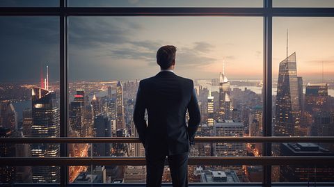 An executive standing in front of a modern high-rise overlooking a bustling city.