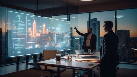 An expert IT engineer demonstrating a new software solution to hotel managers in a boardroom.