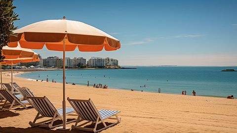 Coastline resort properties with the iconic beach umbrellas and sunbathers in the foreground.