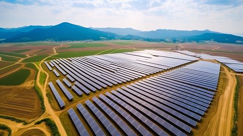 Aerial view of a large solar panel array under construction in a rural China landscape.